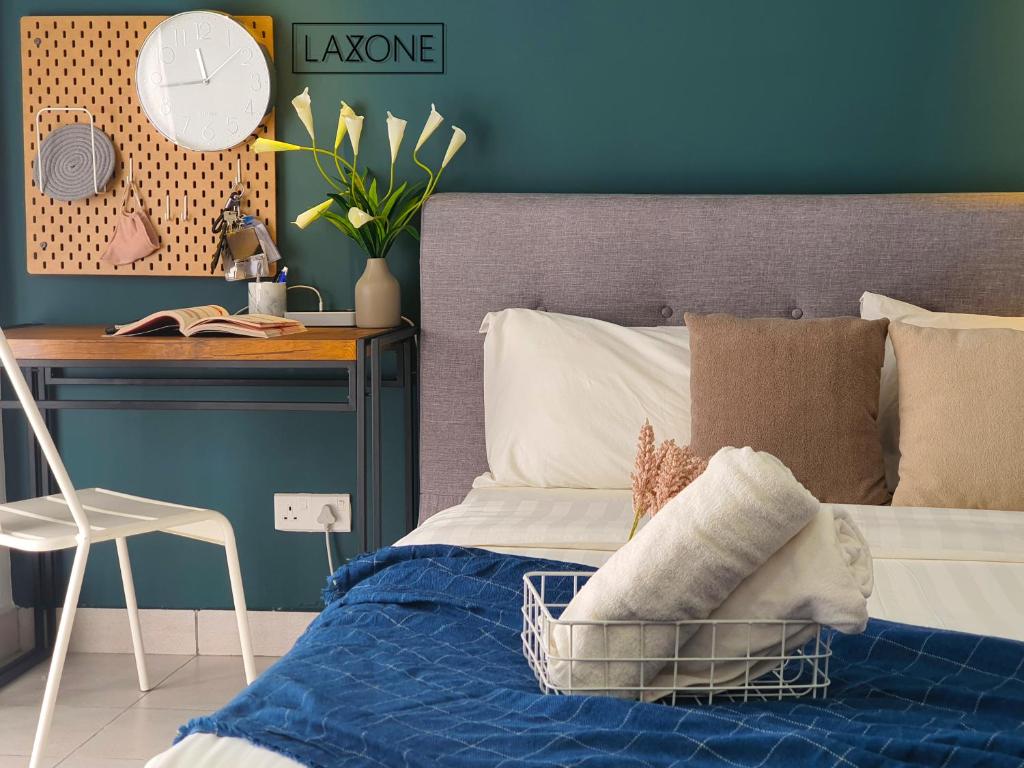 a bedroom with a bed with a blue wall at Aeropod Studio- Laxzone Suite in Kota Kinabalu