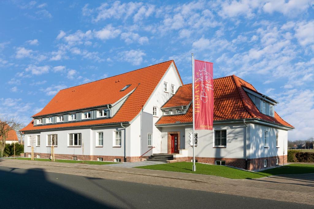 ein großes weißes Gebäude mit orangefarbenem Dach in der Unterkunft Tiemanns Boardinghouse in Lemförde