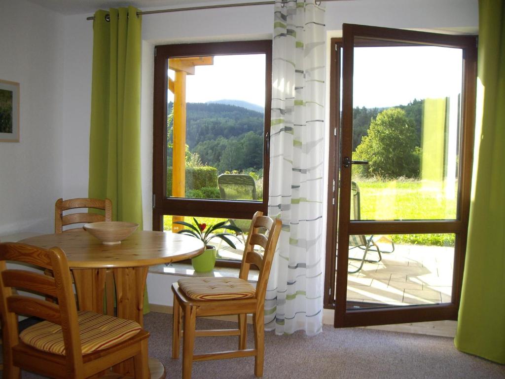 una sala da pranzo con tavolo, sedie e finestra di Ferienwohnung Am Stachelsrain a Zella-Mehlis