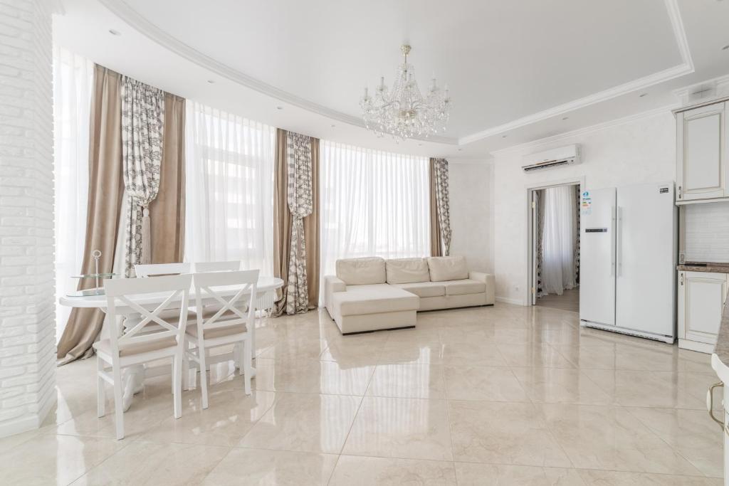 sala de estar blanca con mesa y sofá en Gagarin Plaza Panoramic Sea View Apartment, en Odessa