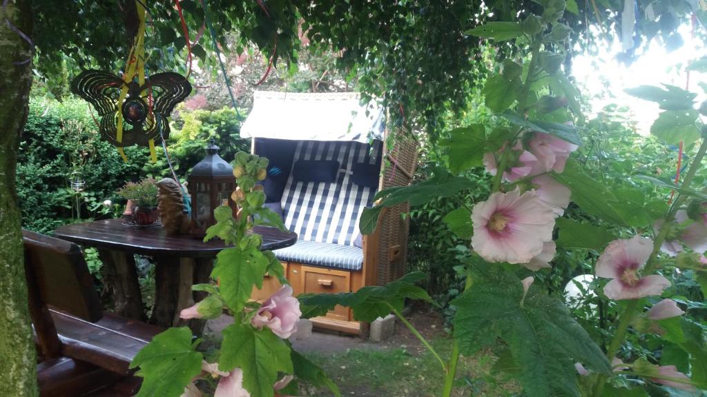 een tuin met een stoel, een tafel en bloemen bij Heideperle3a in Mönchhagen