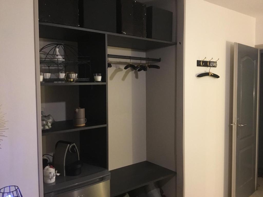 a closet with black shelves in a room at Mon rêve in Les Martys