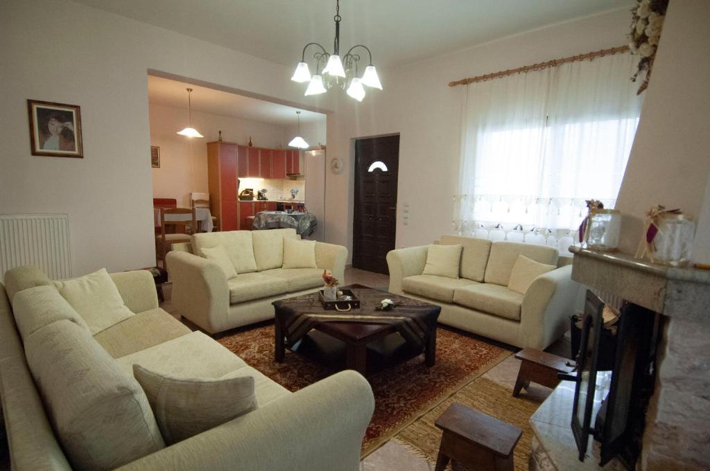 a living room with white couches and a table at Elati Electra's Cozy House in Elati Trikalon