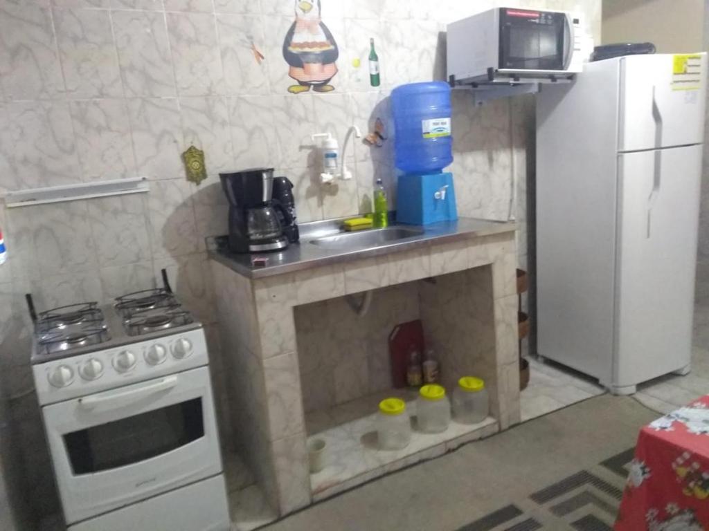 Una pequeña cocina con estufa y refrigerador. en Santo Ivo 3, en Aparecida