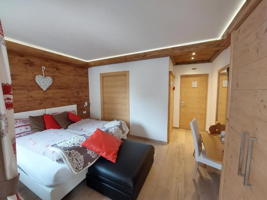 een slaapkamer met een wit bed met rode kussens bij B&B A Ceda Toa in San Pietro di Cadore