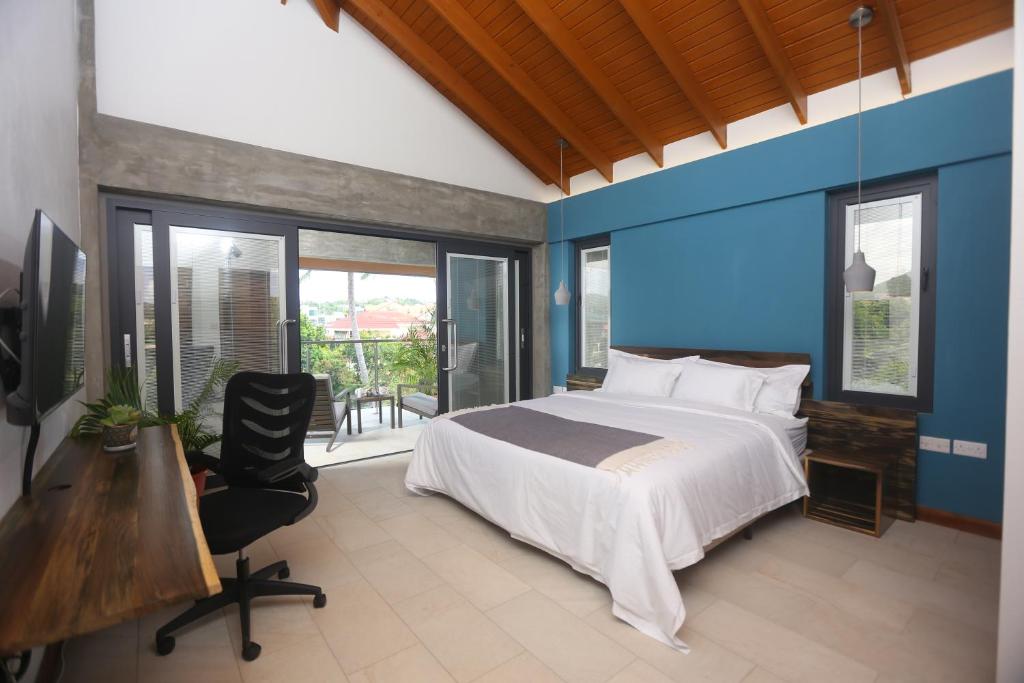 una camera con letto, scrivania e finestre di Sol Sanctum - Boutique Wellness Hotel a Gros Islet