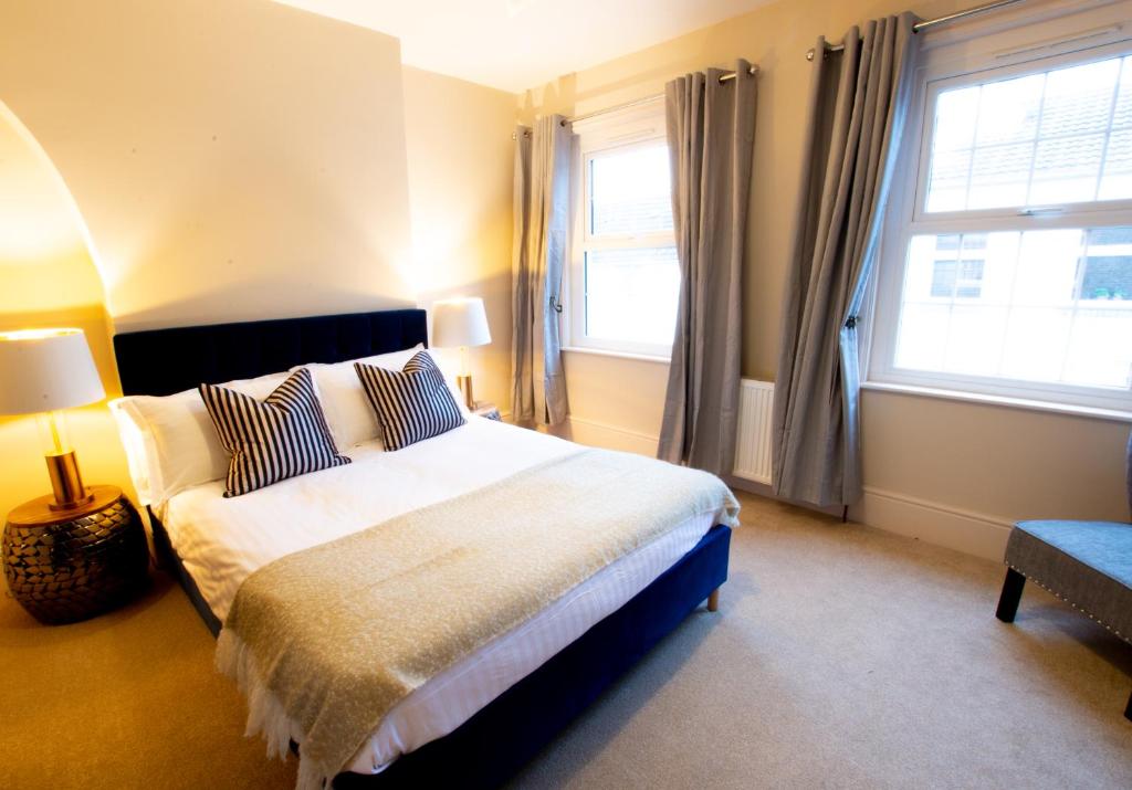 a bedroom with a large bed and two windows at Salisbury Residence by Charles Hope in Salisbury