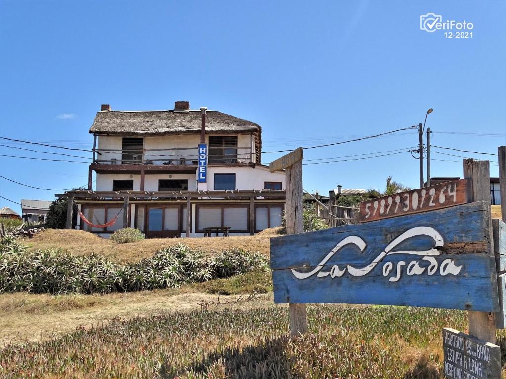 una señal frente a un edificio con una casa en La Posada, en Punta del Diablo