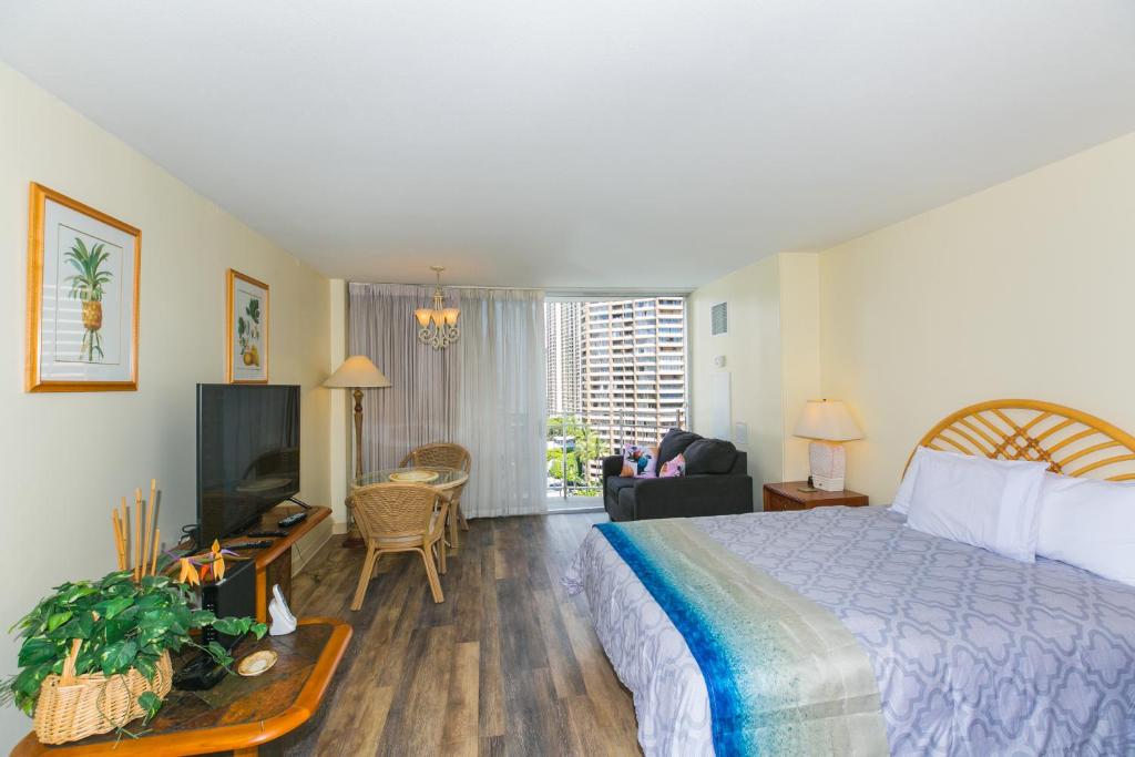 ein Hotelzimmer mit einem Bett und einem TV in der Unterkunft Ilikai Marina 1381 City View Studio in Honolulu