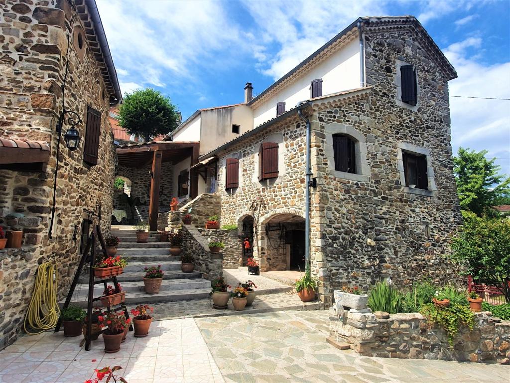 a stone building with stairs and potted plants at Mes Maisons, Two Luxury Gites for 8 or 5 guests with Private Swimming Pool Aircon Laundry Disco or Play Room free WiFi and Linen and Dog's are Welcome in Gagnières