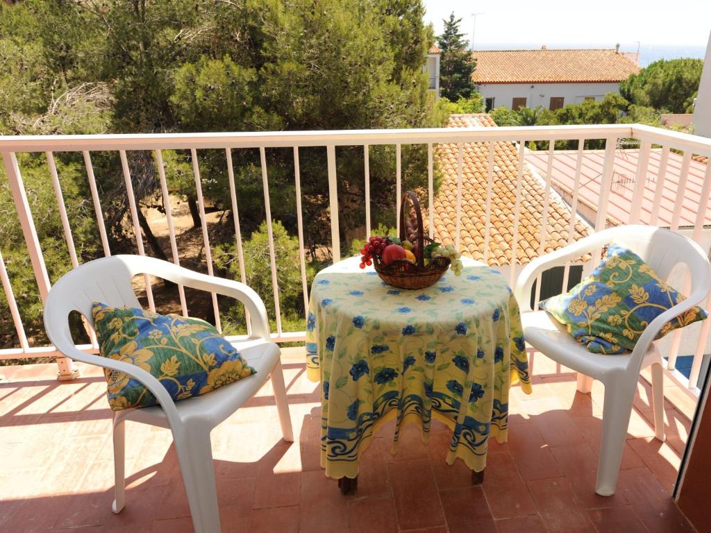 a table and two chairs with a table and a basket of fruit at Apartment Sant Antoni de Calonge in Sant Antoni de Calonge