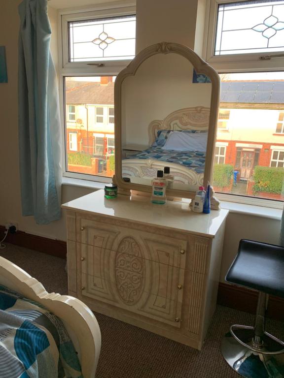 a dressing table with a mirror in a bedroom at Busy Bee - Guest House - Self Service in Leigh