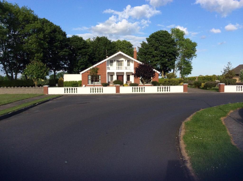 a house with a white fence on a street at Oakdale Templemore, E41Y650 in Templemore