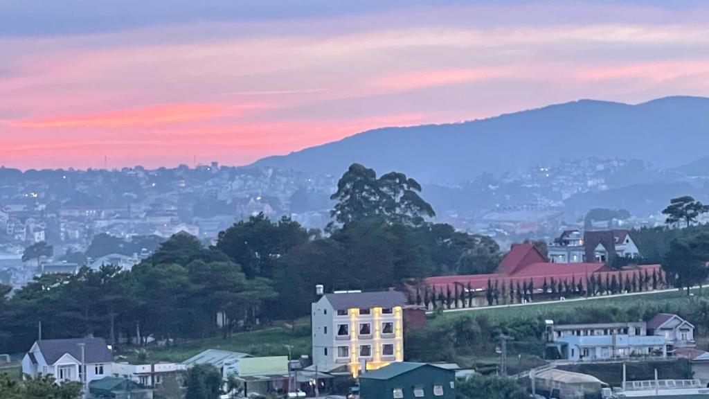 a city with a building on a hill at sunset at Villa Délight House “Stay&Chill” in Da Lat