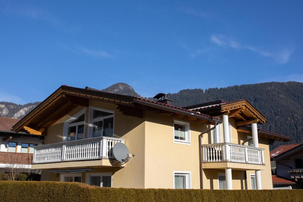 a house with two balconies and a mountain in the background at Apartment Maria in Schlitters