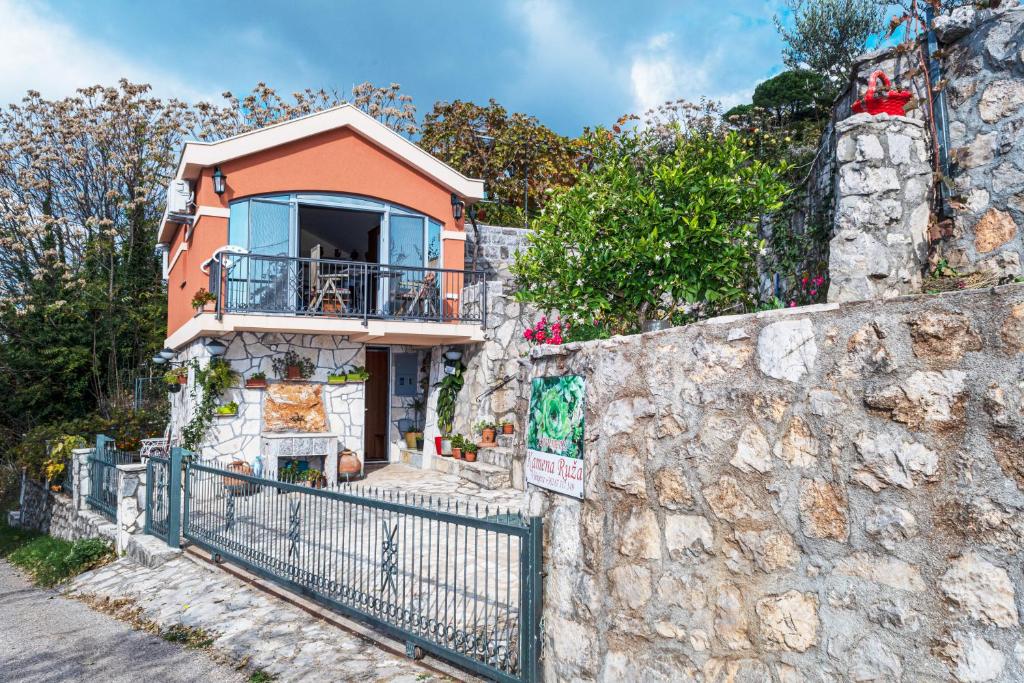 a house on the side of a stone wall at Apartmani Kamena Ruža in Budva