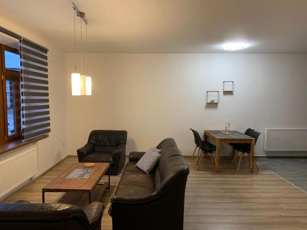 uma sala de estar com um sofá e uma mesa em Apartmán na náměstí em Králíky