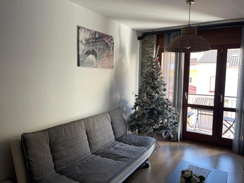una sala de estar con un árbol de Navidad y un sofá en Piso Victoria, en Guardiola de Berguedà