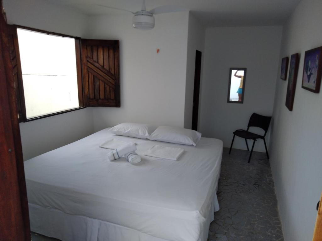 a bedroom with a bed with white sheets and a window at Vi&Li Suites in Aracaju