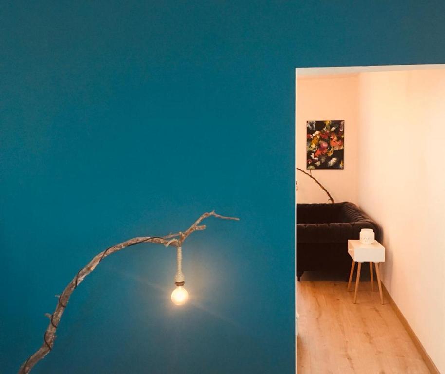 un salon avec un mur bleu et une lampe dans l'établissement Le Gîte de Zao avec billard, à Philippeville