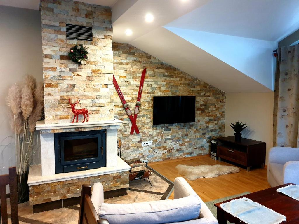 ein Wohnzimmer mit einer Ziegelwand und einem Kamin in der Unterkunft Apartments Elegance in Bansko