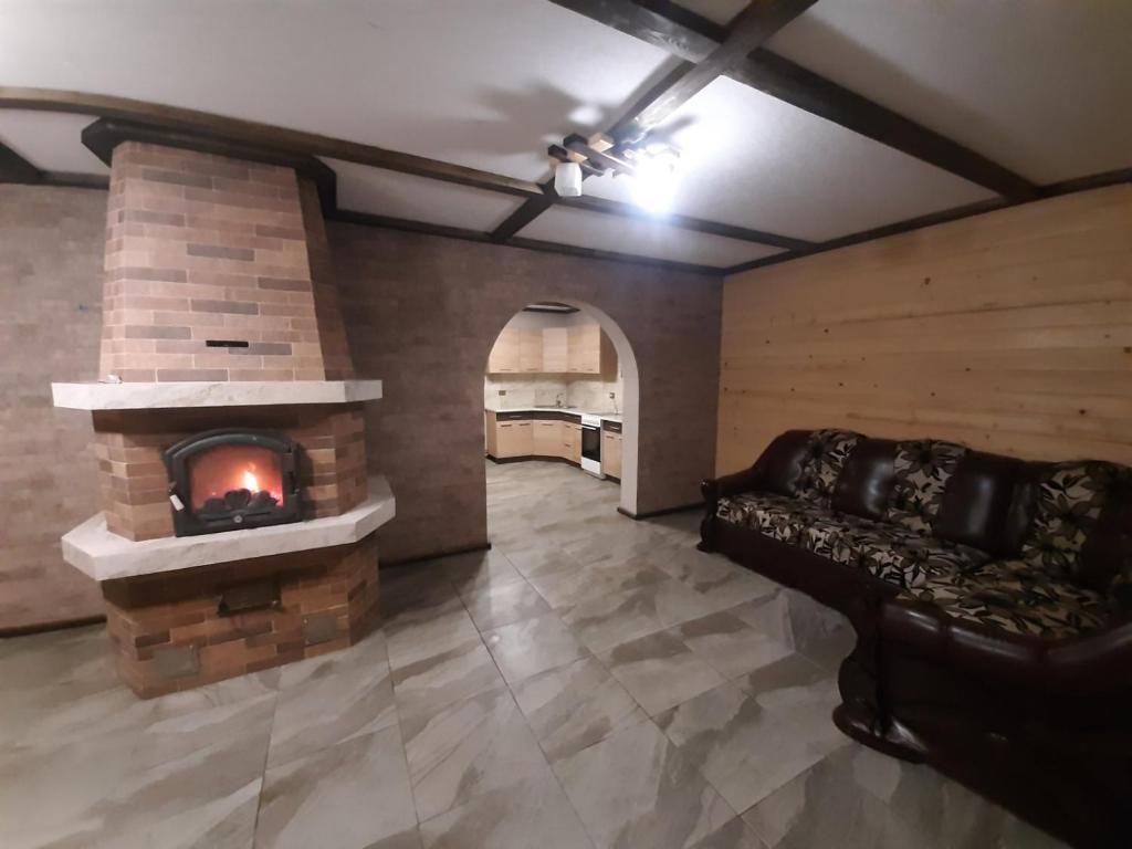 ein Wohnzimmer mit einem Kamin und einem Sofa in der Unterkunft Синевирський Краєвид in Synewyr