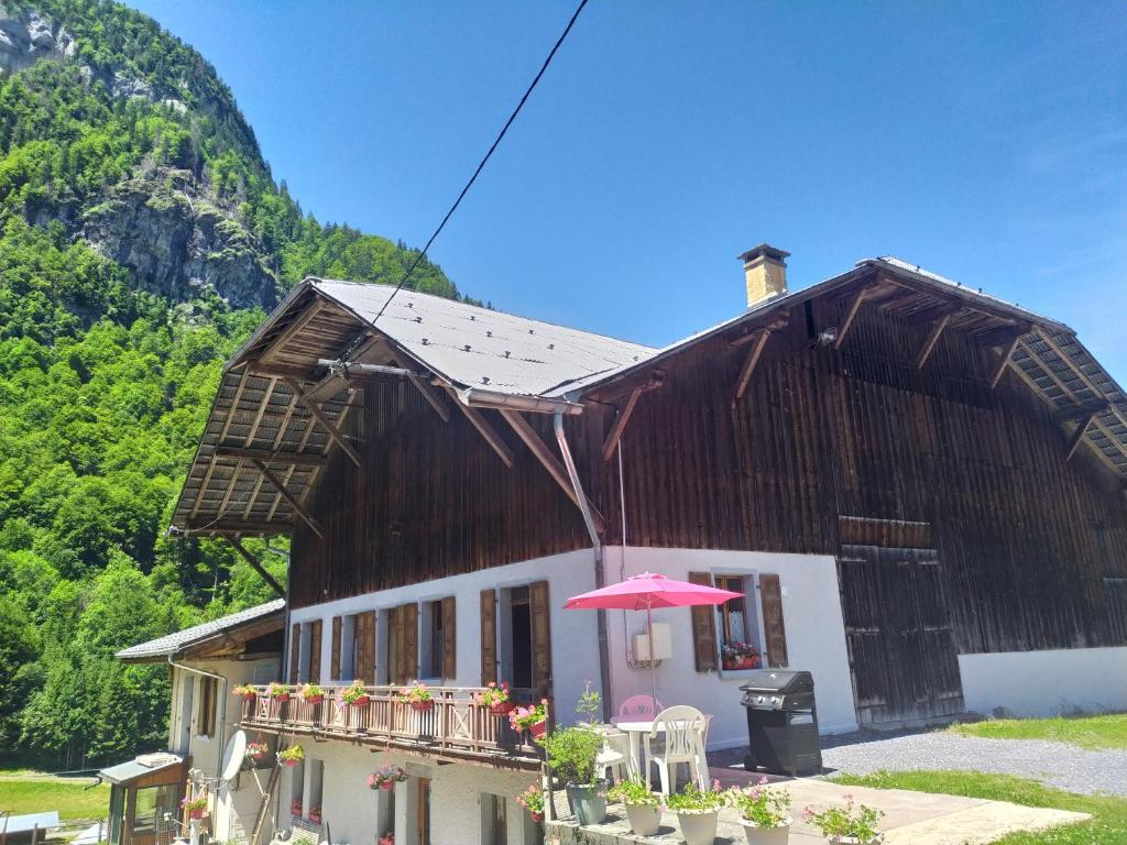 a house with an umbrella in front of it at La Ferme De Fernand in Sixt