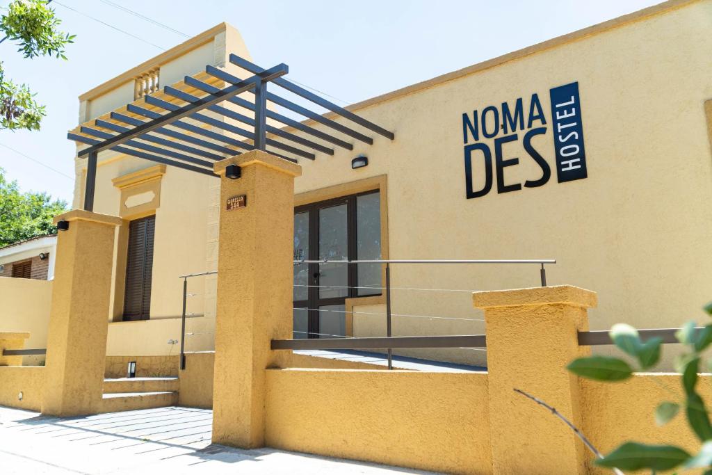 a building with a sign that reads nova digs at Nomades Hostel in Alta Gracia