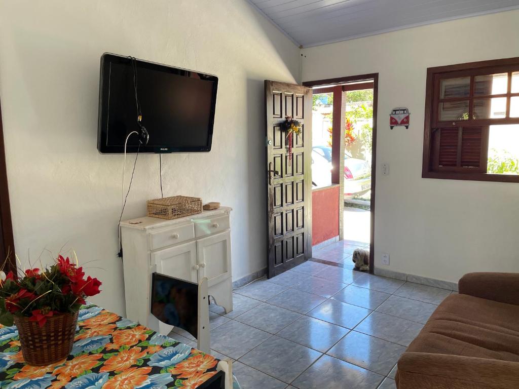 a living room with a flat screen tv on the wall at Vila Colorida casa 2 in Fazendinha