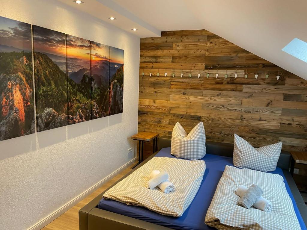 two beds in a room with a wooden wall at Ferienwohnung Oberallgäu Ferienpark mit Schwimmbad in Missen-Wilhams