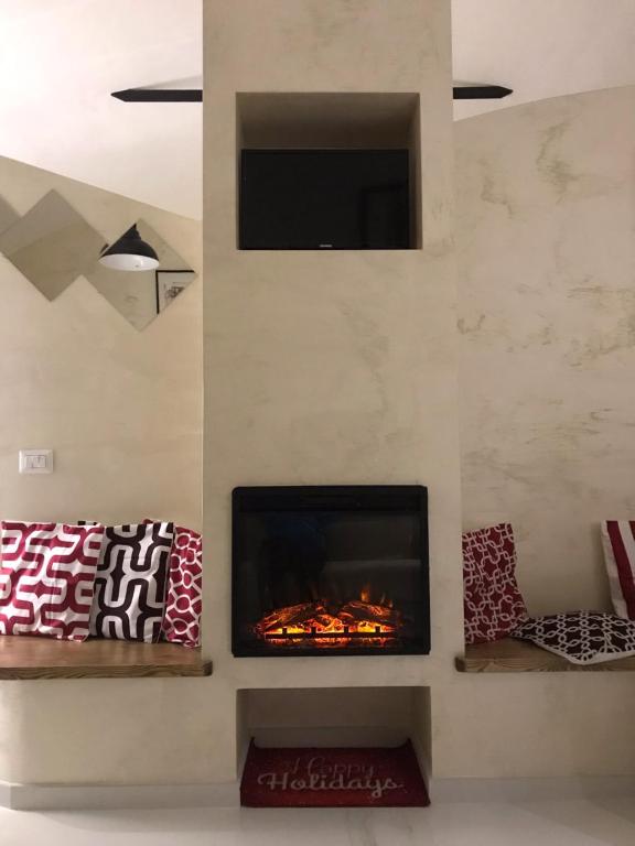 a living room with a fireplace and a tv at La Stella d'oro in Orvieto