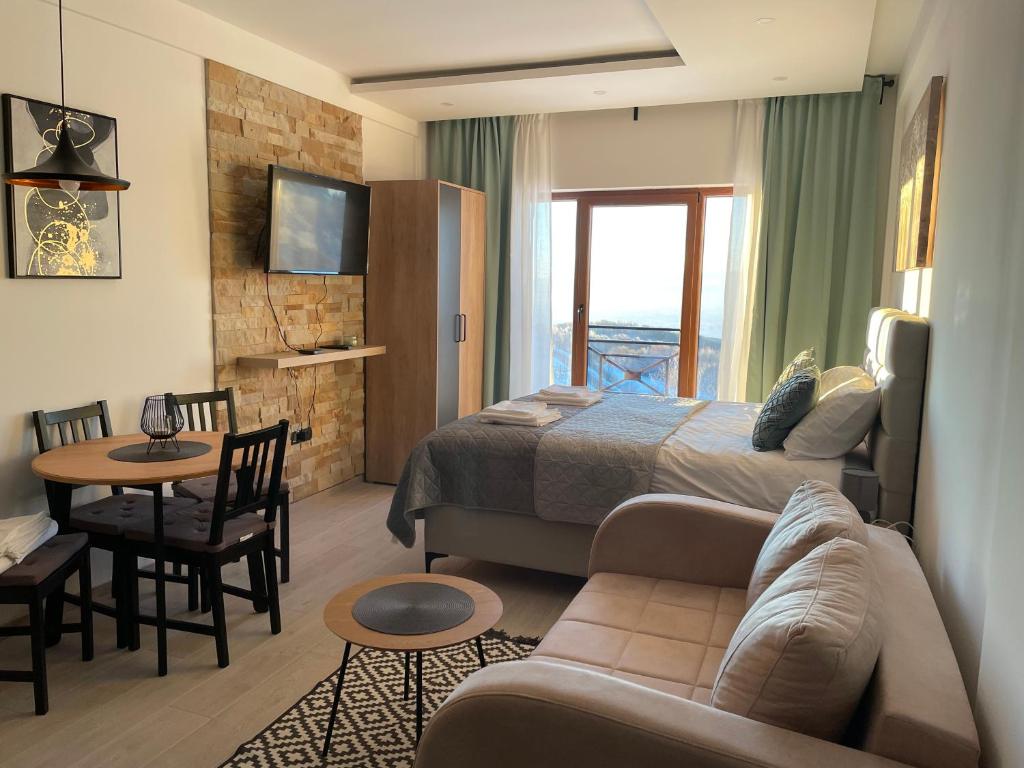 a bedroom with a bed and a living room at Milmari Spa & Wellness, N22 Apartman sa pogledom in Kopaonik