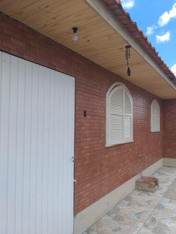 białe drzwi garażowe w budynku z cegły w obiekcie Edícula Prudentópolis w mieście Prudentópolis