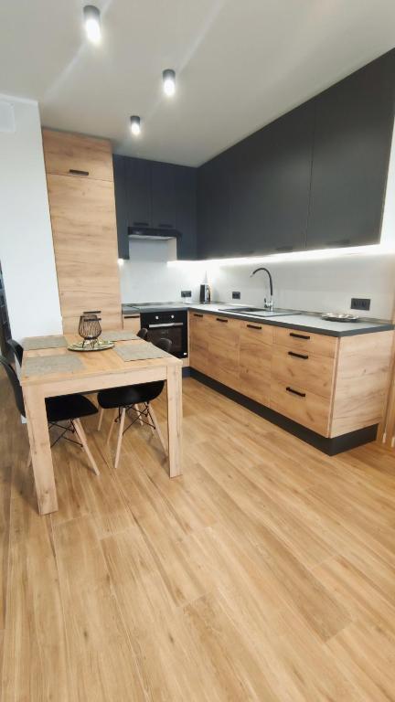 eine Küche mit einem Holztisch und Holzböden in der Unterkunft Apartament 10 in Płock