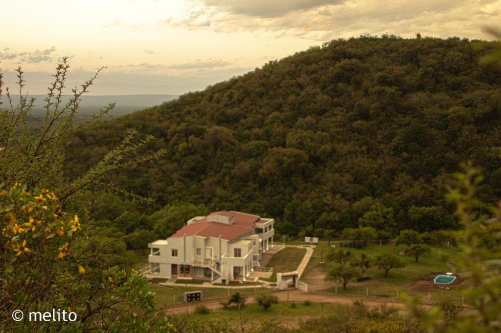 a house on top of a hill with a mountain at La Herradura Village in Merlo