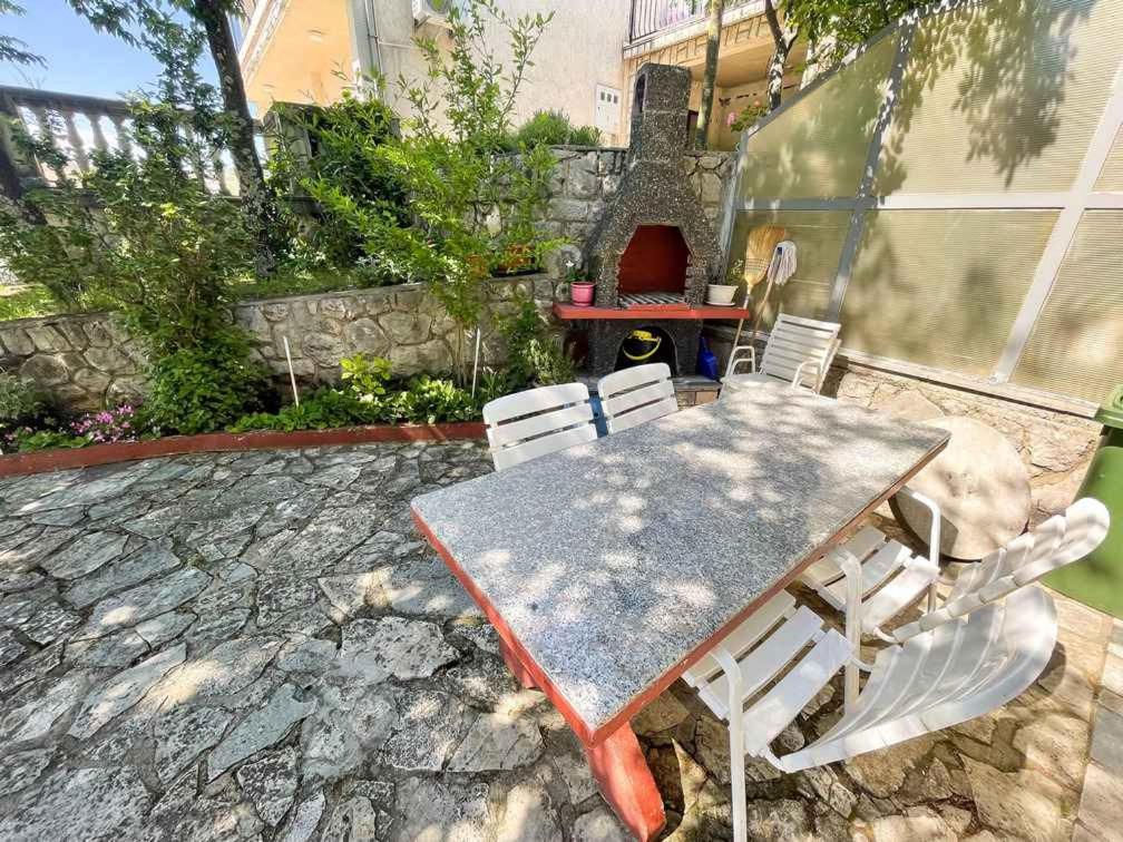- une table et des chaises sur une terrasse avec barbecue dans l'établissement Apartment in Jadranovo 41878, à Jadranovo