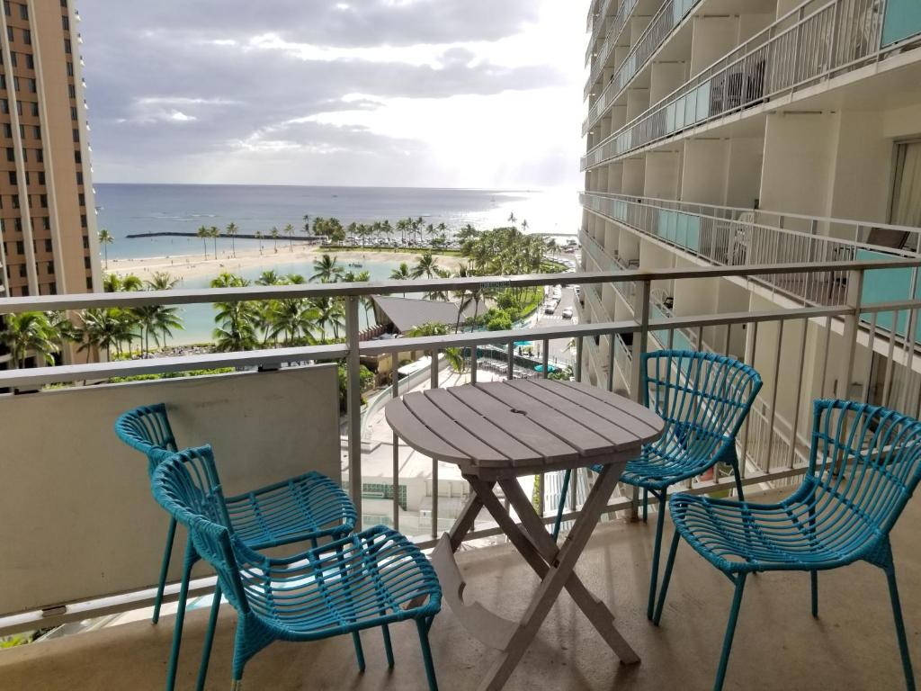a table and chairs on a balcony with a view of the beach at Ilikai Tower 912 in Honolulu