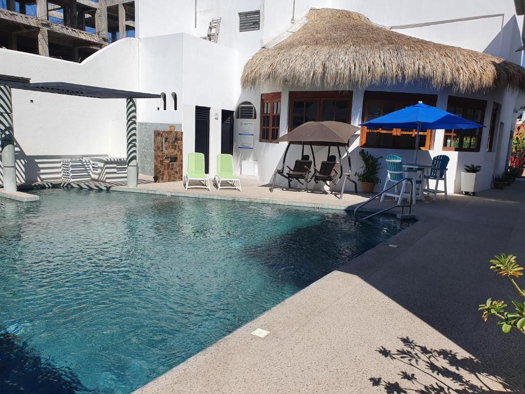 聖克魯斯瓦圖爾科的住宿－Hotel Boutique Eden Costa，一座带椅子和遮阳伞的游泳池位于一座建筑旁边