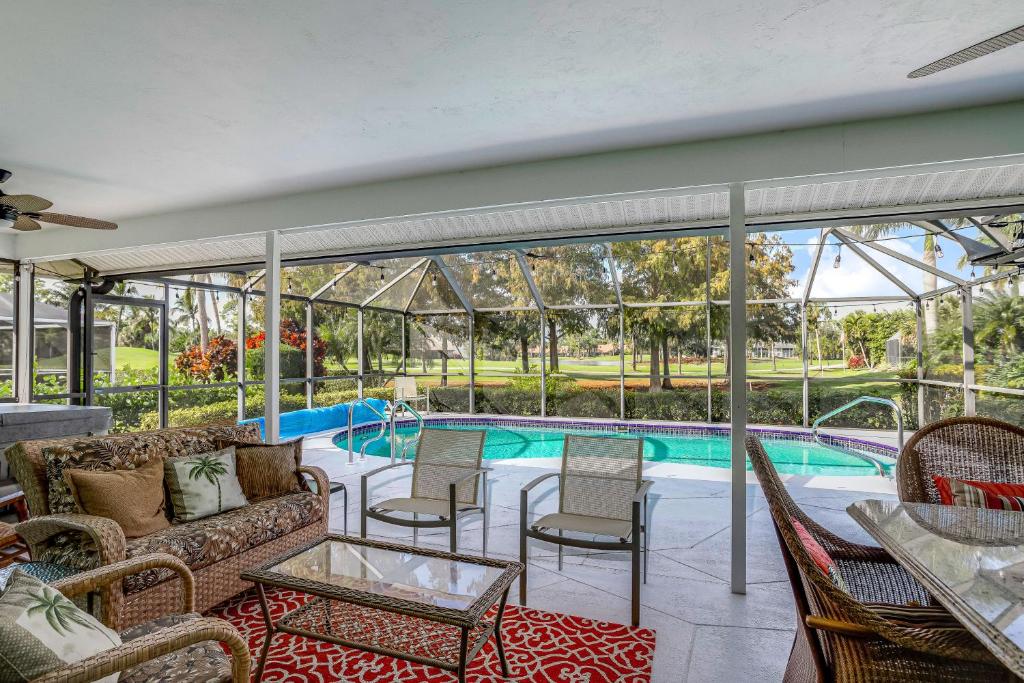 a patio with a couch and chairs and a swimming pool at Golf-Course Oasis in Naples