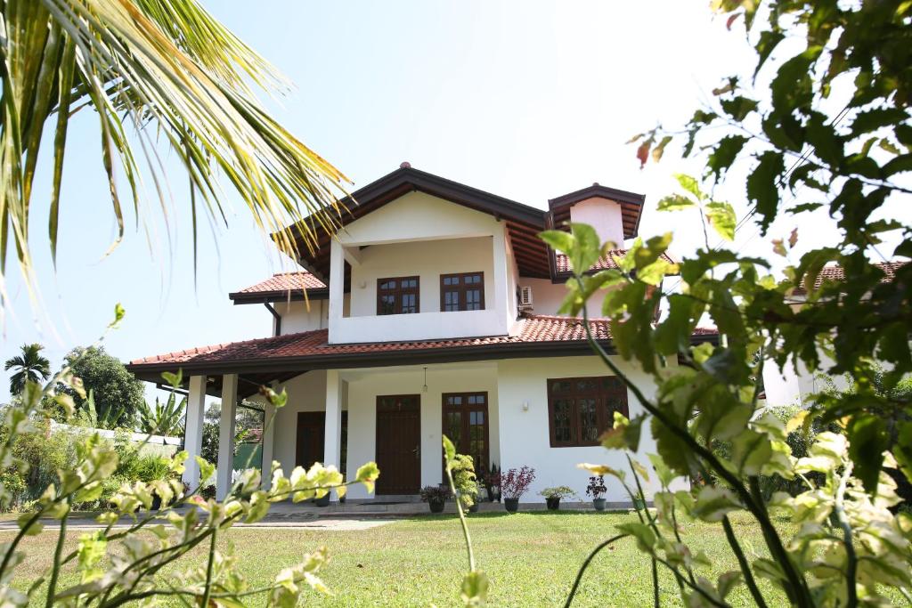 una casa con un césped verde delante de ella en NegomboVilla en Negombo