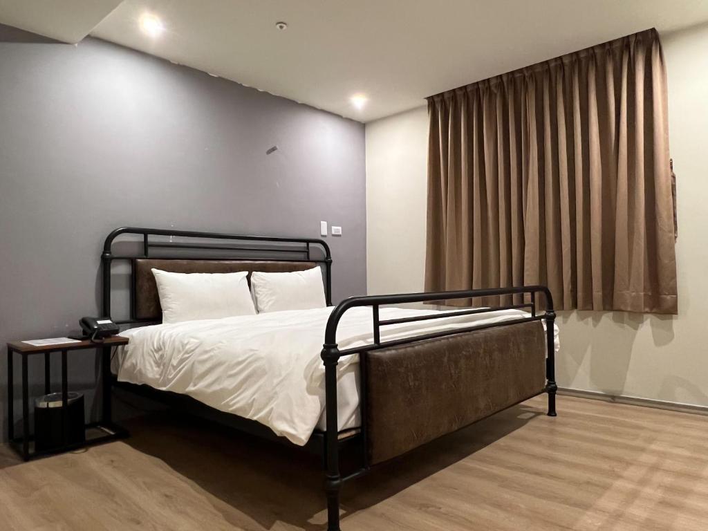 a bedroom with a bed and a window at Saint Hostel in Beigang