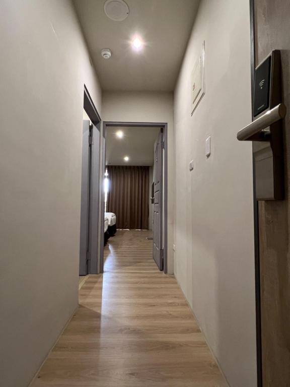 a hallway leading to a room with a bed at Saint Hostel in Beigang