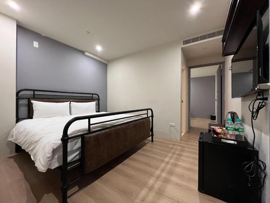 a bedroom with a bed and a flat screen tv at Saint Hostel in Beigang