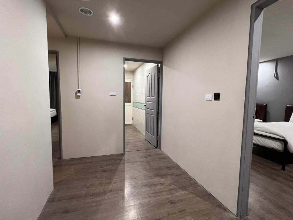 a hallway leading to a bedroom with a bed at Saint Hostel in Beigang