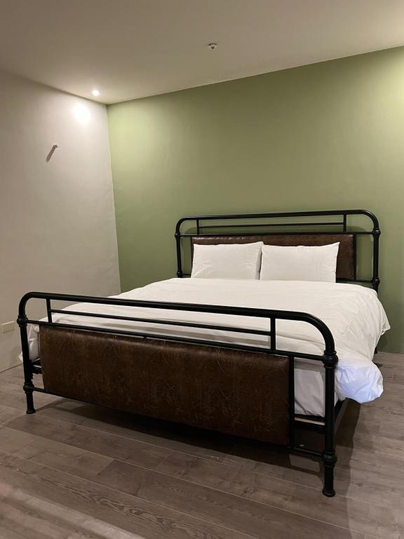a bed with white sheets and pillows in a room at Saint Hostel in Beigang