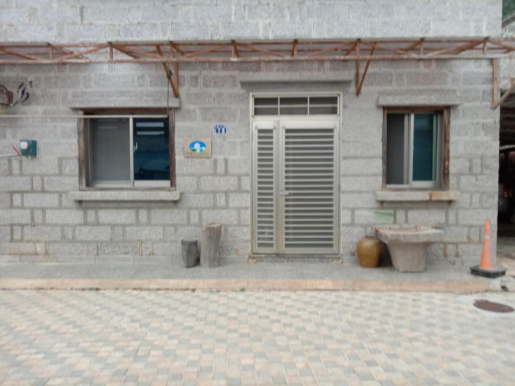 a brick building with two windows and a bench at 雲台客棧民宿 in Nangan