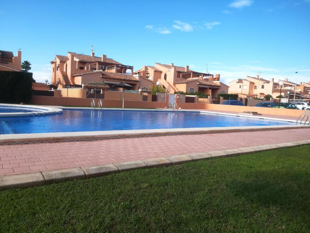 una piscina en un patio con casas al fondo en Urban Altos Del Sol, en Torrevieja