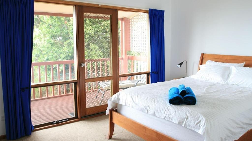 Un dormitorio con una cama con zapatos azules. en Ocean Blue KI. Absolute ocean front, free WiFi, en Penneshaw