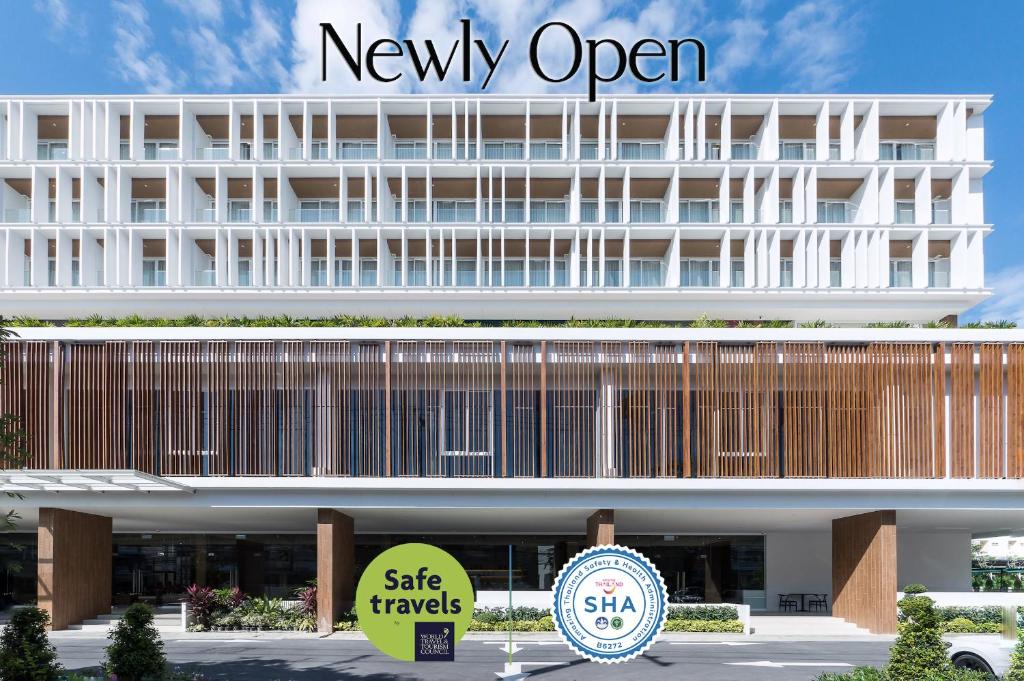 een gebouw met een newxy open bord ervoor bij Shambhala Hotel Pattaya - SHA Plus in Pattaya