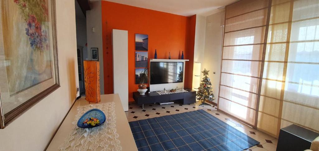 un salon avec des murs orange et une télévision dans l'établissement Happy King, à Lido di Camaiore